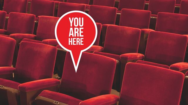 image of red theatre seats with a red dot above one reading You Are Here.